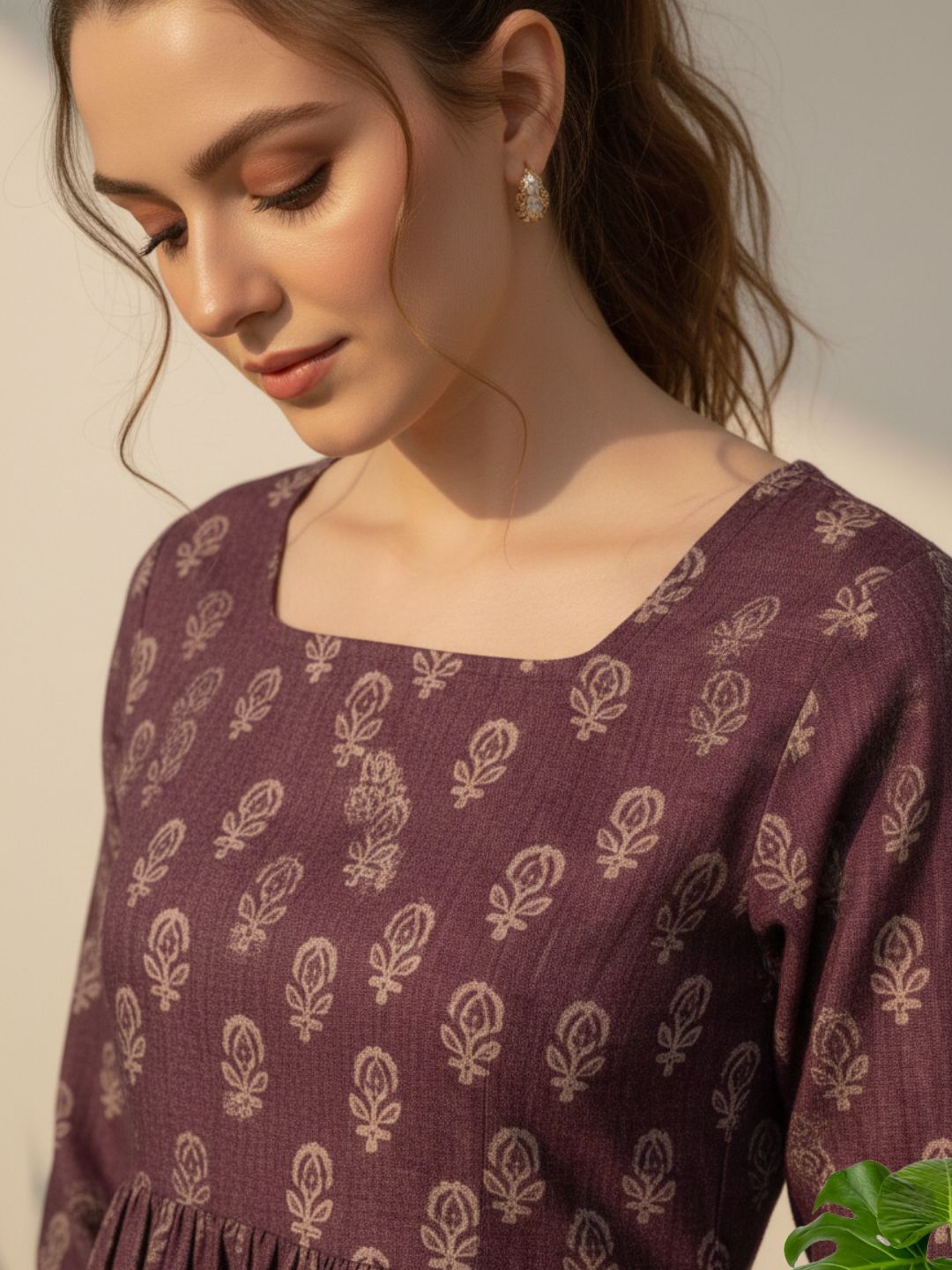 Woman wearing a purple patterned dress against a neutral background