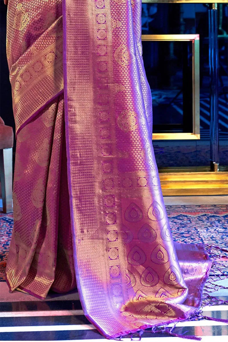 Purple saree with gold patterns draped over a chair in a room.