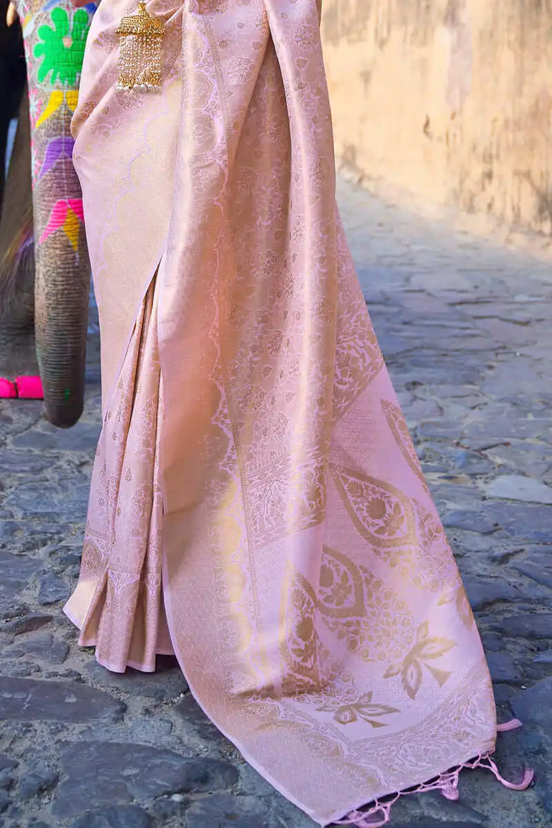 Pink saree with gold patterns on a stone path