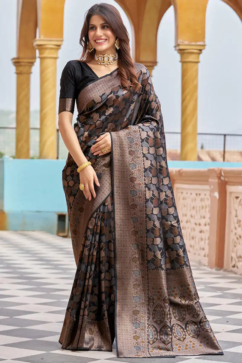 Woman wearing a patterned saree standing in front of architectural columns.