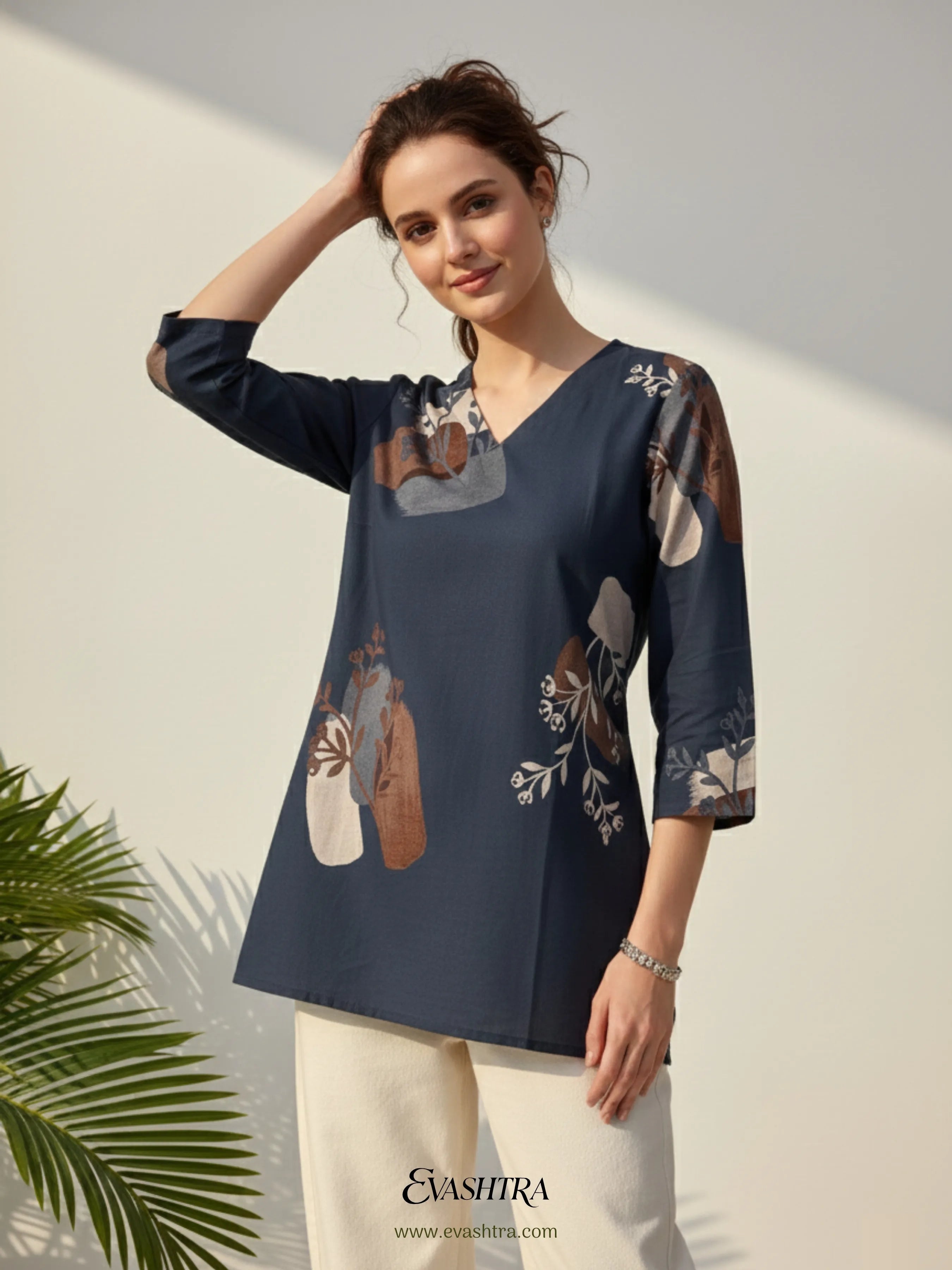 Woman wearing a navy blue blouse with floral patterns against a light background