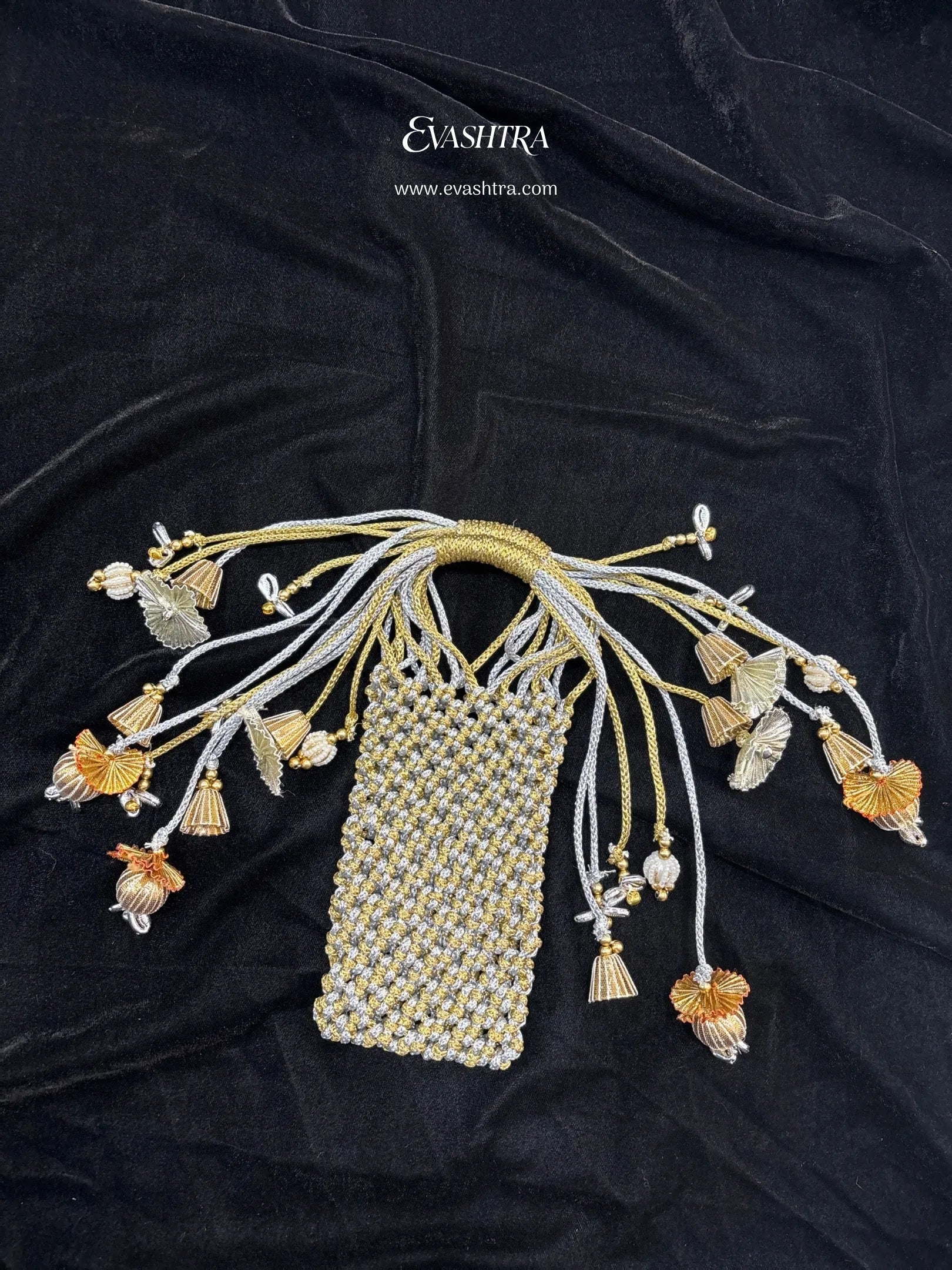 Decorative hairpiece with floral and tassel details on a black fabric background, featuring the brand 'Eva Shri'.