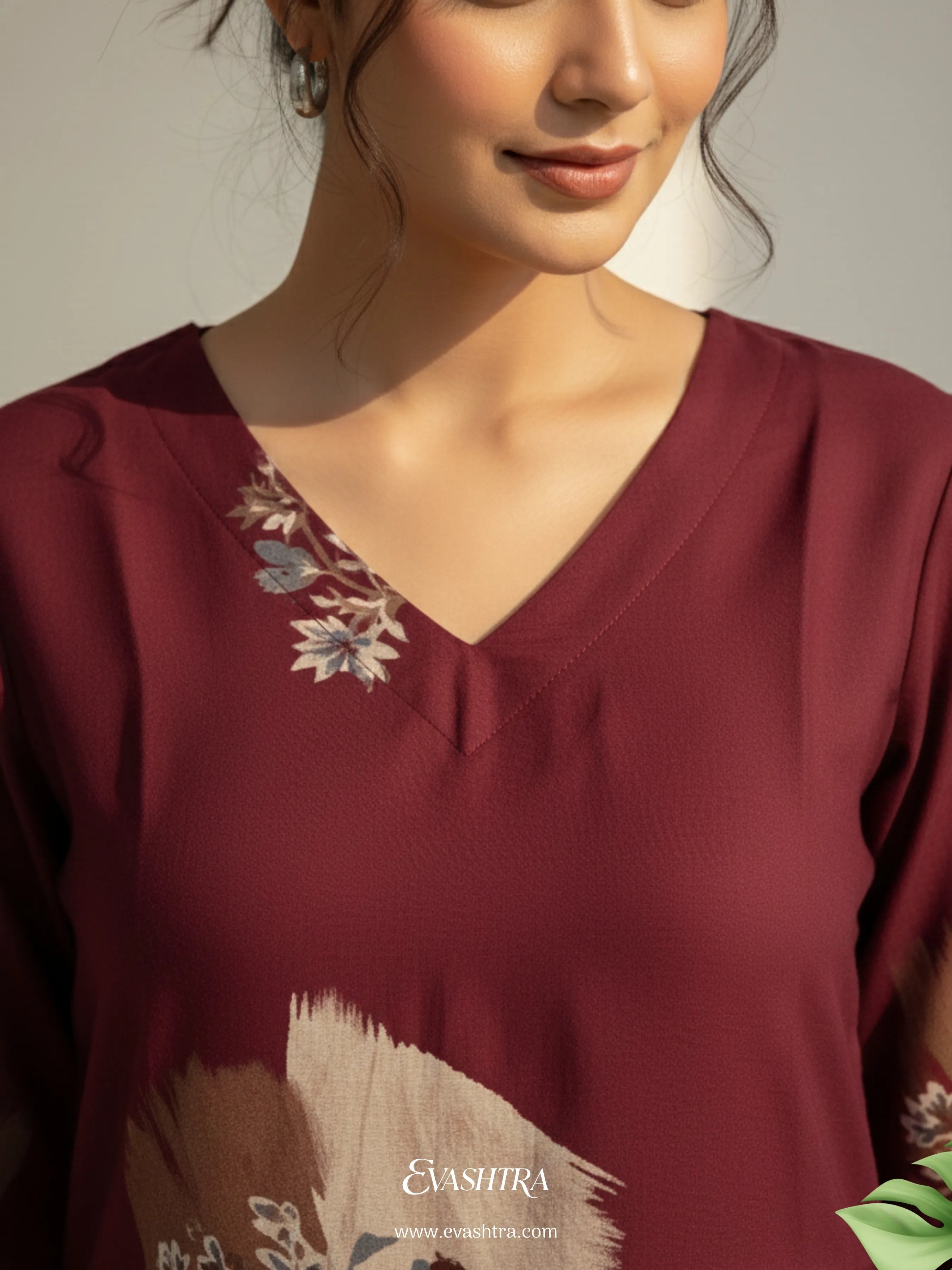 Maroon top with floral embroidery on a plain background
