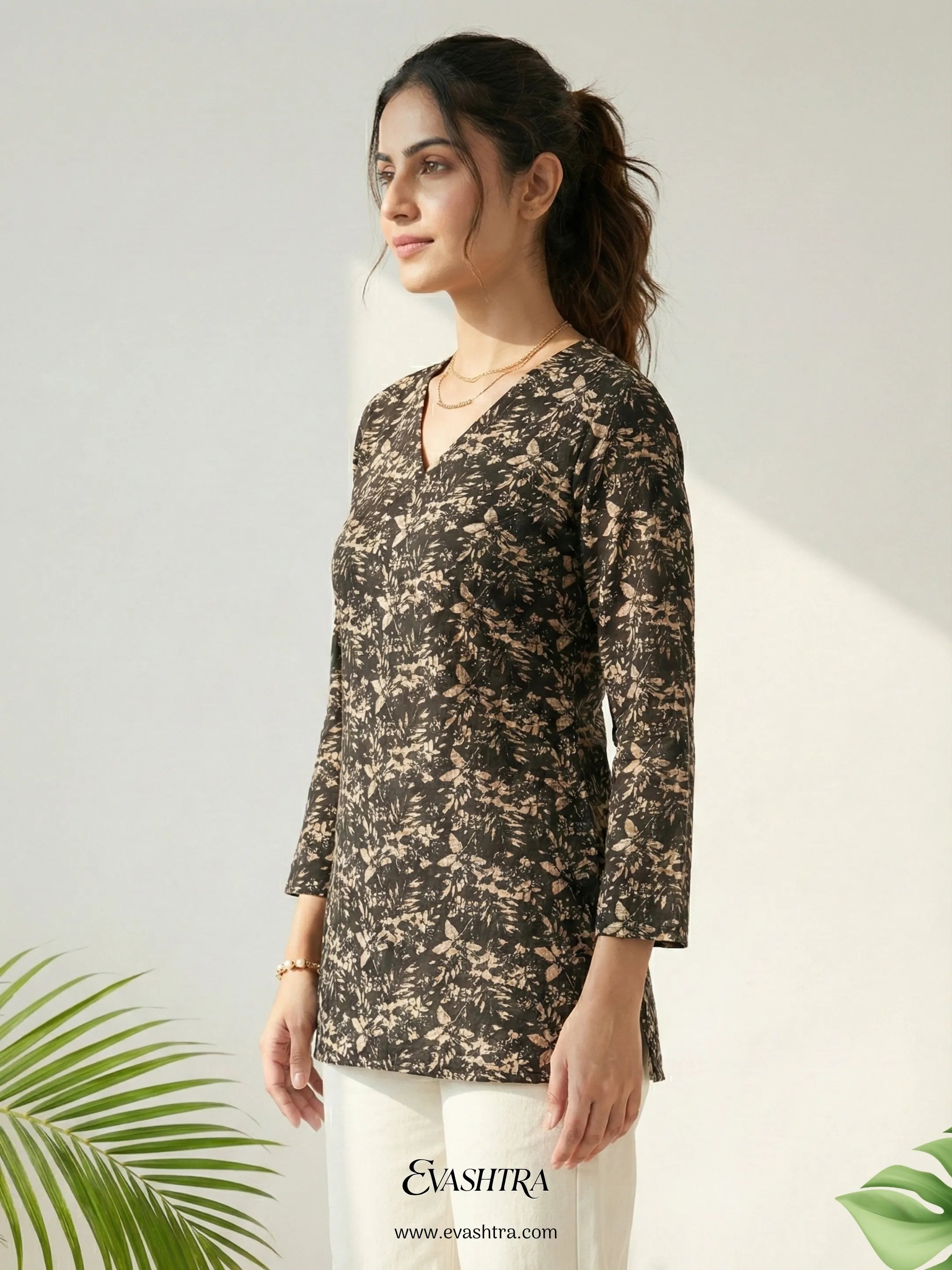 Woman wearing a floral patterned top with a plain background and 'Evastra' branding.