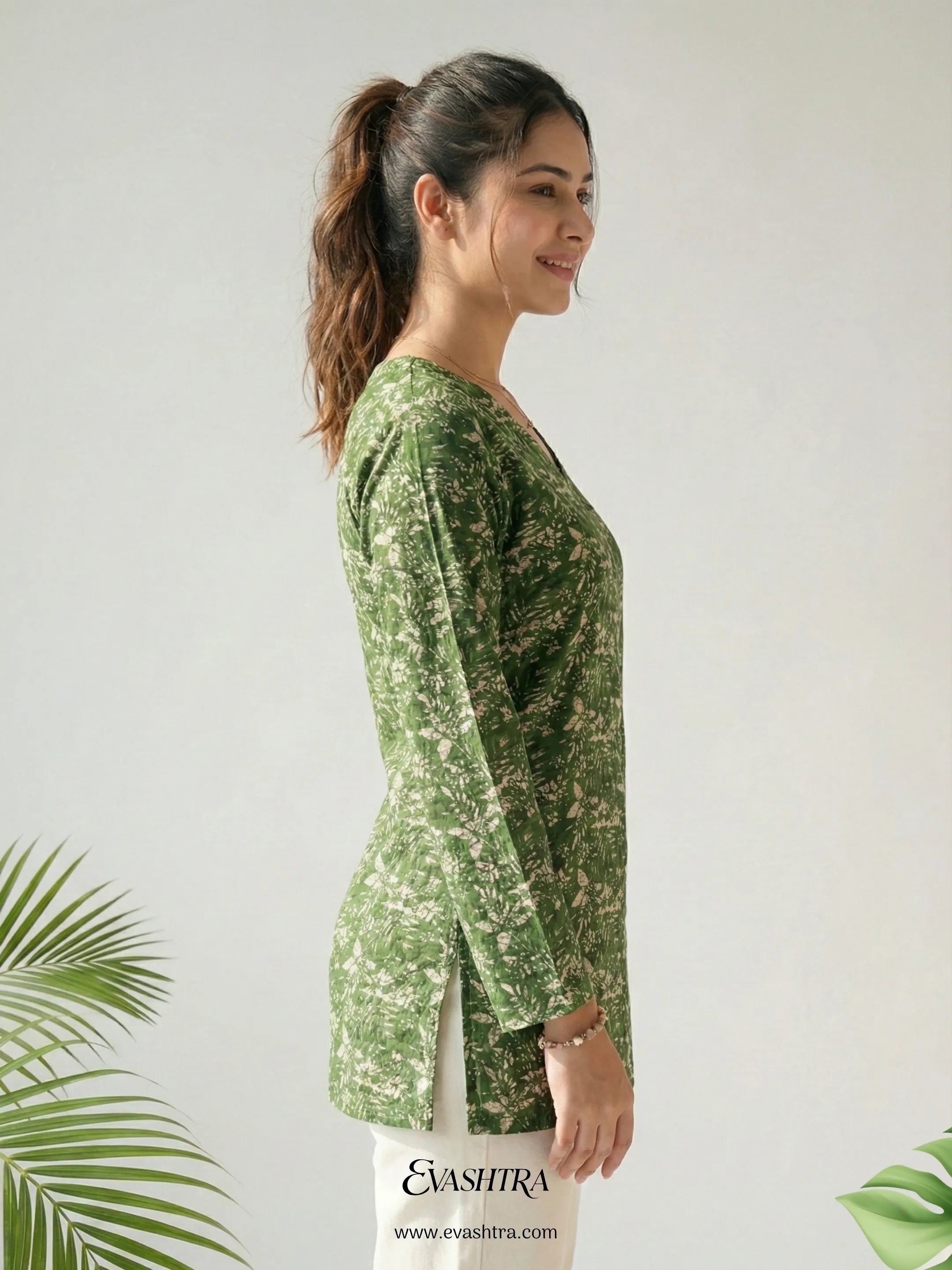 Woman wearing a green patterned outfit with a white background and 'EvaShira' branding.