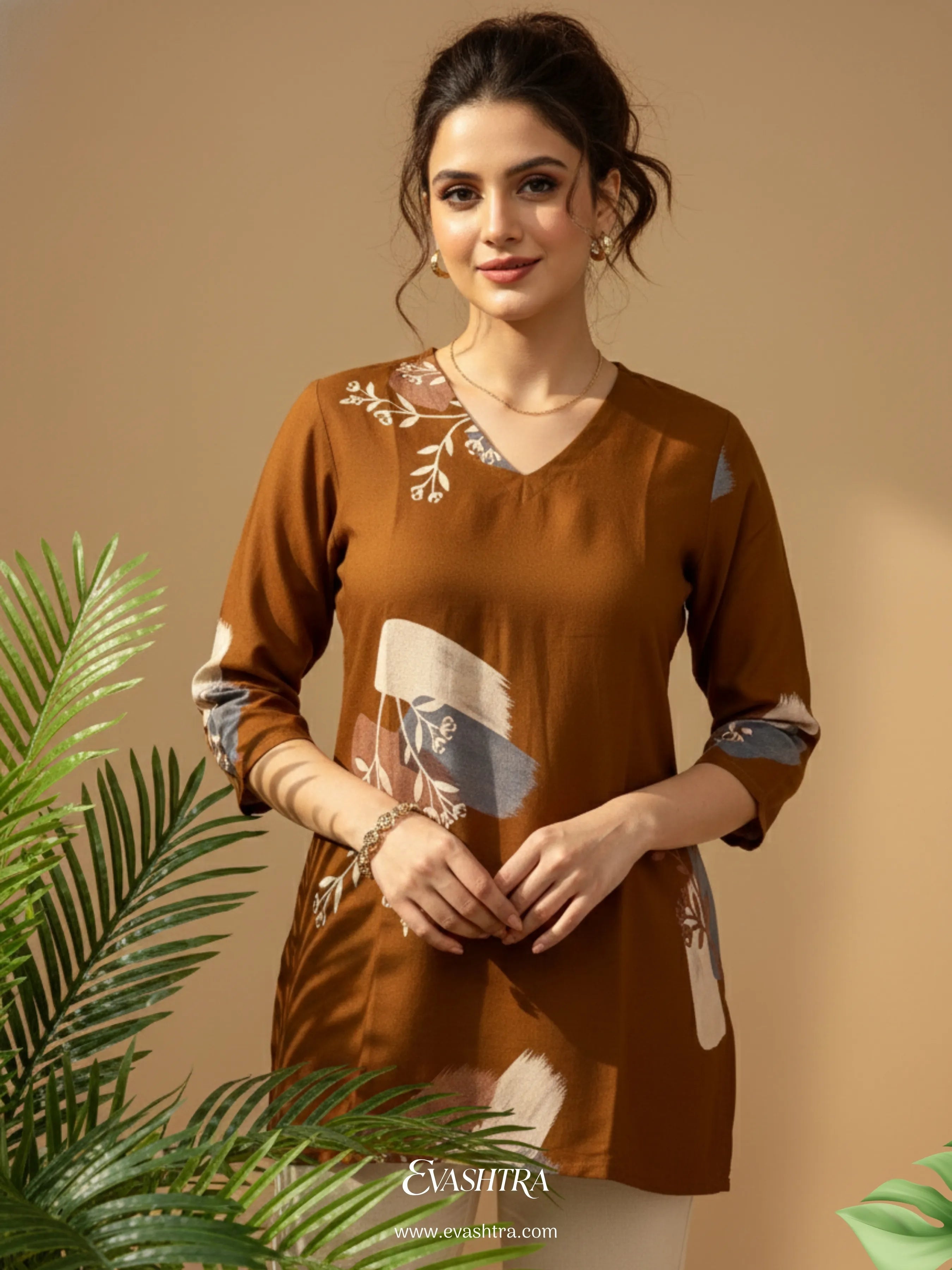 Woman wearing a brown embroidered top with a neutral background