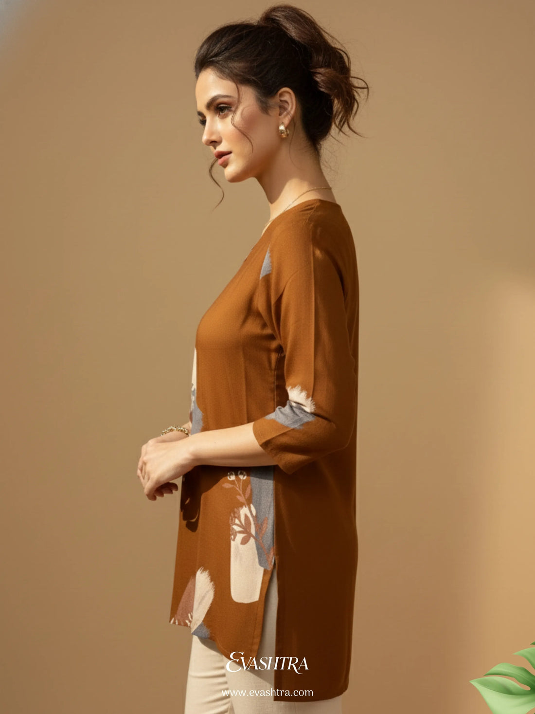 Woman wearing a brown long-sleeve top with floral patterns on a beige background