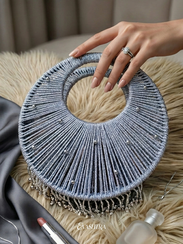 Hand holding a textured blue circular object on a beige surface 