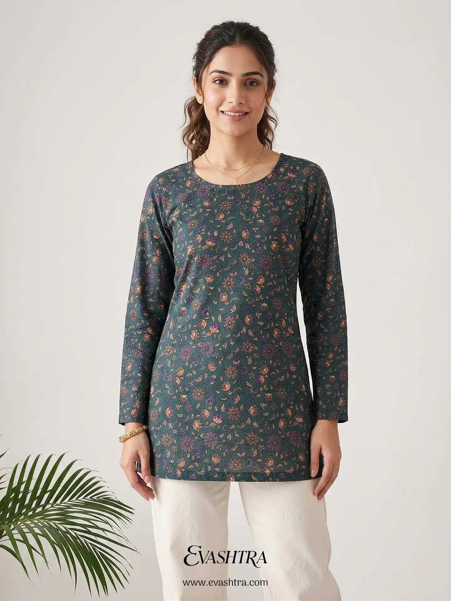 Woman wearing a floral long-sleeve top with a plain background, featuring the brand 'Evastra'.
