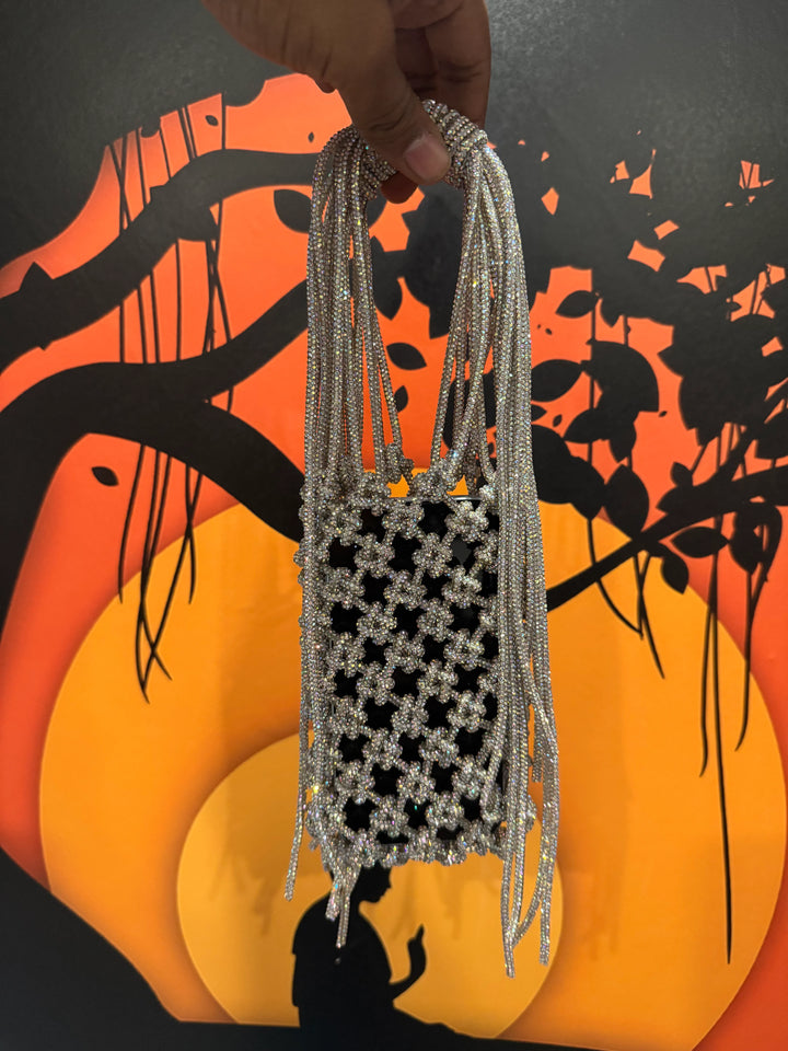 Handmade bag with beaded strings against a colorful abstract background