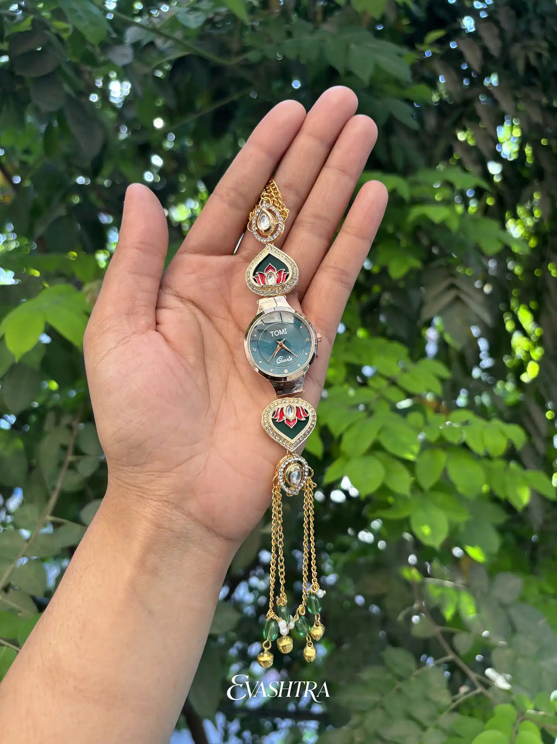 Decorative keychain held in a hand with a green leafy background